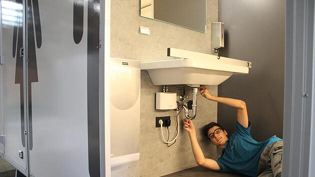 Tizian Gebert &uuml;berpr&uuml;ft vor der Vermietung, ob alle Installationen bei dem VIP-Toilettenwagen funktionieren. Heike Beudert