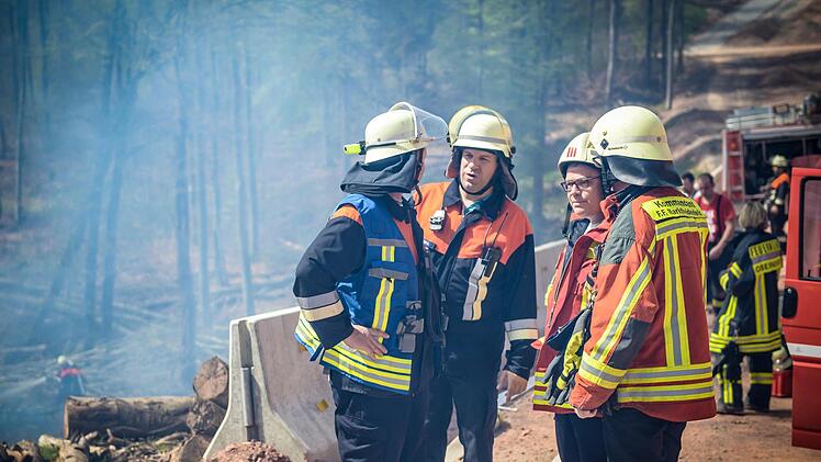 Nach fünf Stunden haben Einsatzleiter Harald Merz (2. von rechts) und seine Leute den Brand nahe der A 3 unter Kontrolle. Foto: Benedict Rottmann