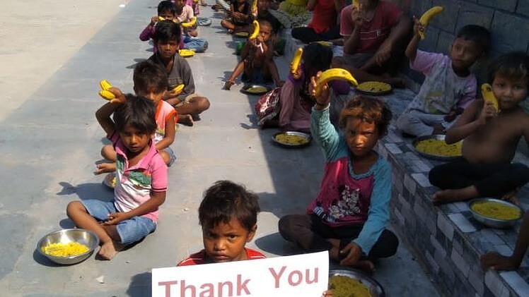 Verteilung der Essensrationen in den Slums von Kapalibagan, Kalkutta, Indien  Father Foto: Father Mathew-George