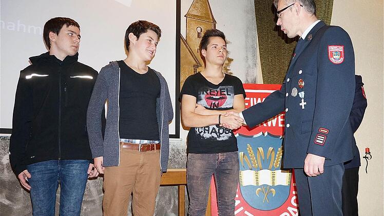 Mit dem traditionellen Handschlag begrüßte Kommandant Holger Amend (rechts) die Neuen bei der Waizenbacher Wehr (von links): Kevin Ullrich, Jannis Fürsch und Luca Biemüller. Foto: Gerd Schaar