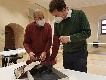 Historiker Marcus Mühlnikel vom Institut für Fränkische Landesgeschichte und Thomas Grelich (links), der Sohn der Firmengründer, mit einem in Thurnau gefertigten Stiefel
