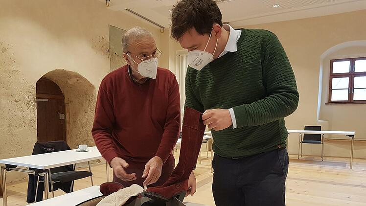 Historiker Marcus Mühlnikel vom Institut für Fränkische Landesgeschichte und Thomas Grelich (links), der Sohn der Firmengründer, mit einem in Thurnau gefertigten Stiefel