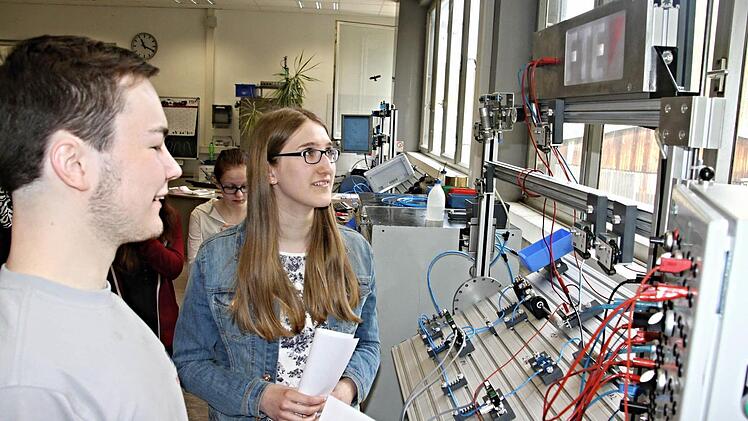 Wie funktioniert eine elektropneumatische Schaltung. Das erklärt Fabian Binger (links), Azubi zum Mechatroniker anhand eines Planes und an der Schalttafel der Schülerin Eva Seuß (rechts) aus Ebern. Foto: Helmut Will