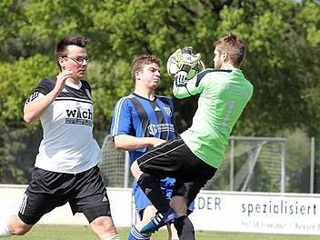 Kreisklasse 3: Burghaslachs Keeper Daniel Hausmann (rechts) klärt vor dem Pettstadter Michael Baldauf (Mitte). Verteidiger Ulrich Rost wäre wohl zu spät gekommen. Fotos: Sportpress