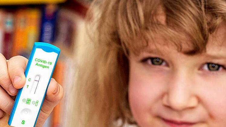 Kind hält negativen Corona Antigen-Test in der Hand