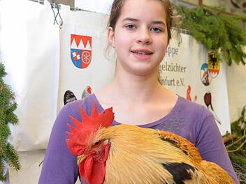 Hannah Hertlein mit einem lachsfarbenen Hahn der Rasse Bassette. Foto: Peter Rauch