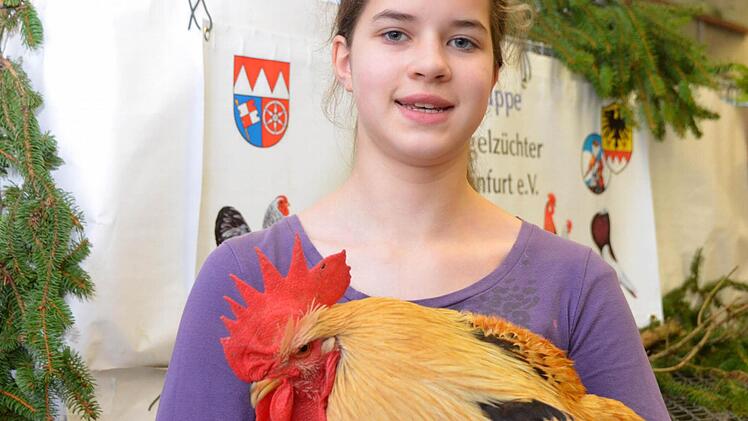 Hannah Hertlein mit einem lachsfarbenen Hahn der Rasse Bassette. Foto: Peter Rauch