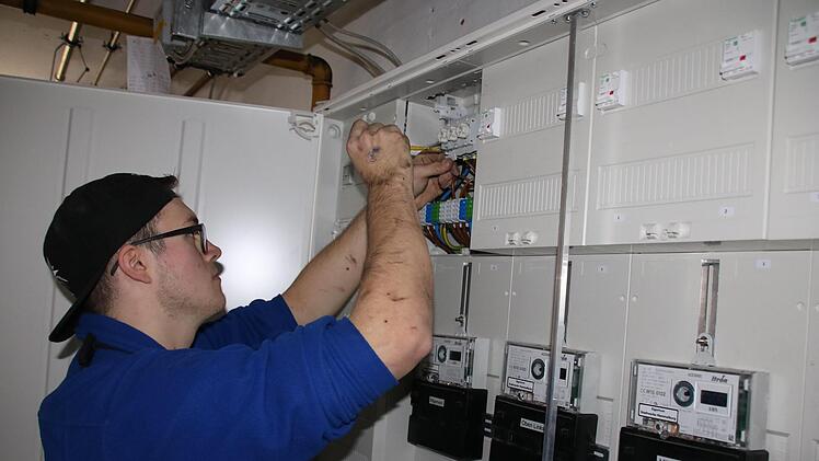 Elektriker Louis Seifried klemmt die neuen Stromleitungen an. Foto: Ralf Ruppert