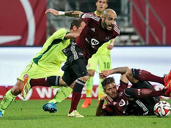 Die N&uuml;rnberger Javier Pinola (M) und J&uuml;rgen M&ouml;ssmer (r) k&auml;mpfen mit dem D&uuml;sseldorfer Erwin Hoffer um den Ball. Foto: Daniel Karmann/dpa