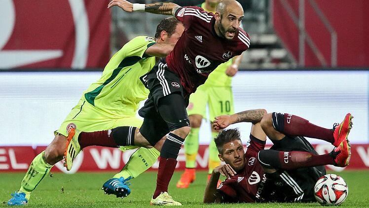 Die N&uuml;rnberger Javier Pinola (M) und J&uuml;rgen M&ouml;ssmer (r) k&auml;mpfen mit dem D&uuml;sseldorfer Erwin Hoffer um den Ball. Foto: Daniel Karmann/dpa