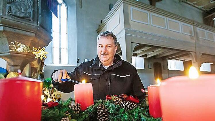Mesner Wilfried Langbein entzündet den Adventskranz.