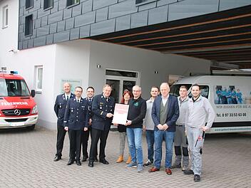 Kreisbrandrat Benno Metz übergibt im Beisein der Feuerwehrführung und der Mitarbeiter die Urkunde an Udo Gebert.  Foto: Thomas Malz