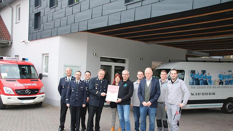 Kreisbrandrat Benno Metz übergibt im Beisein der Feuerwehrführung und der Mitarbeiter die Urkunde an Udo Gebert.  Foto: Thomas Malz