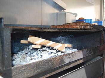 Vorerst wird in den Bratwurstbuden auf dem Coburger Marktplatz auf Kiefernzapfen verzichtet. Unter den Bratwürsten brennt stattdessen Holzkohle und Buchenholz. Foto: Oliver Schmidt
