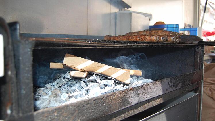 Vorerst wird in den Bratwurstbuden auf dem Coburger Marktplatz auf Kiefernzapfen verzichtet. Unter den Bratwürsten brennt stattdessen Holzkohle und Buchenholz. Foto: Oliver Schmidt