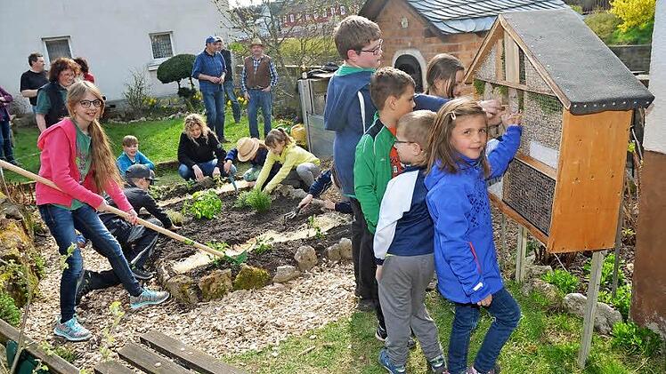 Die "Forscherkids" des Obst- und Gartenbauvereins Neukenroth freuen sich über ihr neues Insektenhotel und legen gerade noch letzte Hand an. Andere Kinder pflanzten und säten Beeren und Kräuter im Forscherkidsgarten, der ein Blickfang in der Ortsmitte von Neukenroth ist. Mit im Bild einige Betreuer vom Obst- und Gartenbauverein  Foto: K.- H. Hofmann