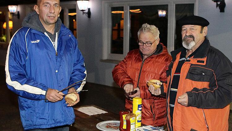 Die beiden SVH-Urgesteine Franz Bauer (r.) und Harald "Fexer" Werner (Mitte) kaufen sich bei Robert Mirwald ein paar Bratwürste.