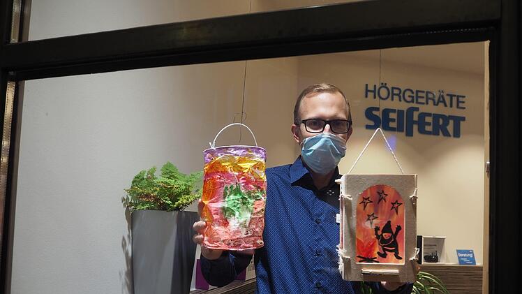 Christoph Heinzel, Leiter der Filiale Hörgeräte Seifert in Coburg, freut sich über die Laternen in seinem Schaufenster. Foto: Cindy Dötschel