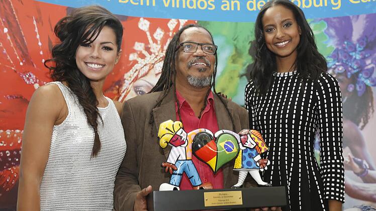 Fernanda Brand&atilde;o (links) und Sara Nuru (rechts) mit einem Musiker der brasilianischen Gruppe "Olodum", der den F&ouml;rderpreis Humano in den H&auml;nden h&auml;lt. Foto: Matthias Hoch