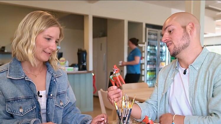 Lina und Daniel bemalen hölzerne Dalapferdchen.