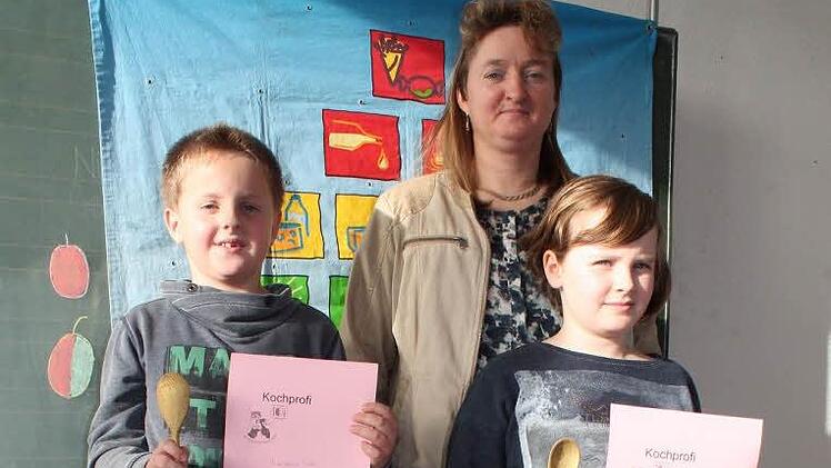 Die Erstplatzierten Melissa Holzheid und Maximilian Fuchs pr&auml;sentieren den Klassenkameraden zusammen mit ihrer Kochlehrerin Petra Grimmer den "Goldenen Kochl&ouml;ffel".