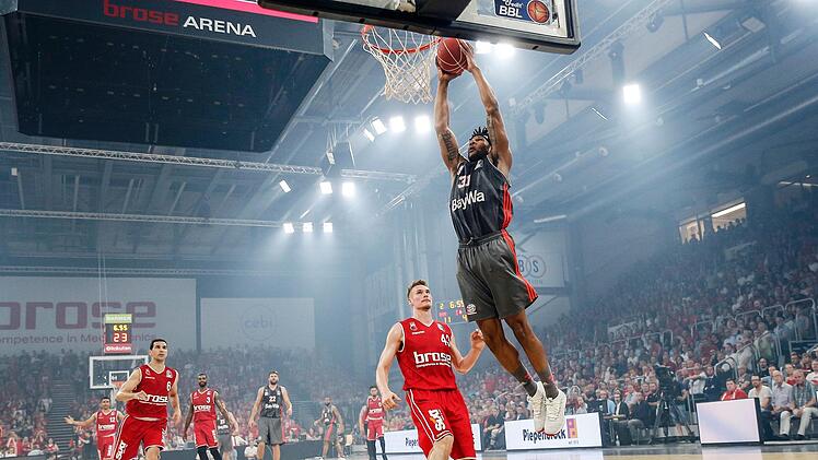 Leon Radosevic kann nur noch zusehen, wie der Münchner Devin Booker den Ball in den Ring stopft.