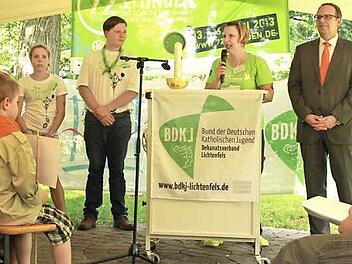 Jutta Laube holt den hereingeschlichenen Landrat Christian Meißner nach vorne und motiviert die Aktionsteilnehmer für das kommende Wochenende. Diese warten währenddessen gespannt auf die Enthüllung der von ihnen zu bewältigenden Aufgaben. Foto: Manuel Stark