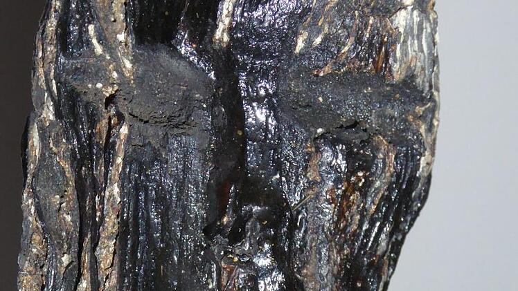 Augen und Nase des Sander Götzen kann man erahnen. Bei der Eichenholz-Skulptur handelt es sich mit großer Wahrscheinlichkeit um einen Kultgegenstand. Gefunden wurde der kleine Holzkopf in den 1960er Jahren am Sander Baggersee - einst Areal einer Kultstätte. Fotos: Knauf-Museum Iphofen