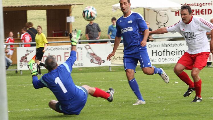 Marco Reich (Mitte), der dreifache Torschütze, lupft den Ball über Auswahltorwart Dieter Kuhn zum 0:2 ins Netz. Erich Köttler (rechts) kommt zu spät.