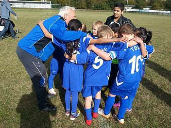 Jugendtrainer Günter Förtsch schwört die Kinder aufeinander auf dem Spielfeld ein. Foto: Manja von Nida