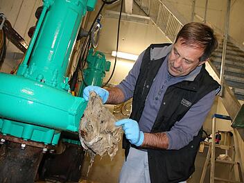 Wie ein langer verfilzter Zopf sieht der Strang an Feuchttüchern aus, den Abwassermeister Albrecht Leurer gerade aus einer der Pumpen in der Hammelburger Kläranlage geholt hat. Regelmäßig fallen Pumpen wegen Abfall im Abwasser aus. Foto: Ralf Ruppert