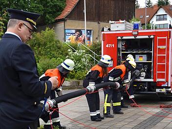 In Sekundenschnelle: Kreisbrandinspektor Ronald Geis stoppt mit einer Uhr, ob die Saugleitung in der vorgegebenen Zeit gekuppelt und mit dem Fahrzeug verbunden wird. Die Feuerwehrler schlagen sich gut. Foto: Kathrin Kupka-Hahn