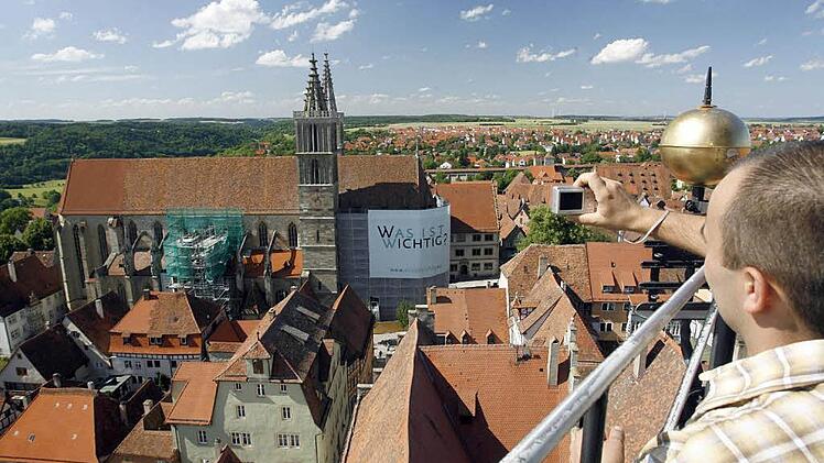 Ein Mann fotografiert vom Rathausturm in Rothenburg ob der Tauber (Mittelfranken) den Blick &uuml;ber die Altstadt und die St-Jakobs-Kirche. Bei ausl&auml;ndischen Touristen ist die Stadt das beliebteste Ausflugsziel in Franken. Archivfoto: Daniel Karmann dpa