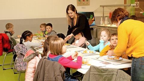 Betreuerinnen gehen den Kleinsten beim Essen etwas zur Hand.