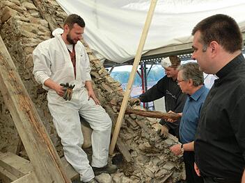 Pfarrer Michal Osak, Kirchenpfleger Franz Frosch sowie die Zimmerer Markus Weimann und Markus Erhardt (von rechts) begutachten die Schäden an der Dachkonstruktion der Ludwigschorgaster Kirche. Foto: Tobias Braunersreuther