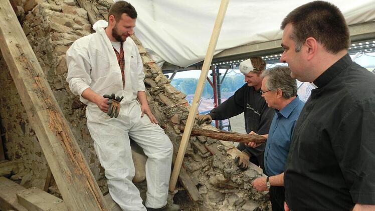 Pfarrer Michal Osak, Kirchenpfleger Franz Frosch sowie die Zimmerer Markus Weimann und Markus Erhardt (von rechts) begutachten die Schäden an der Dachkonstruktion der Ludwigschorgaster Kirche. Foto: Tobias Braunersreuther