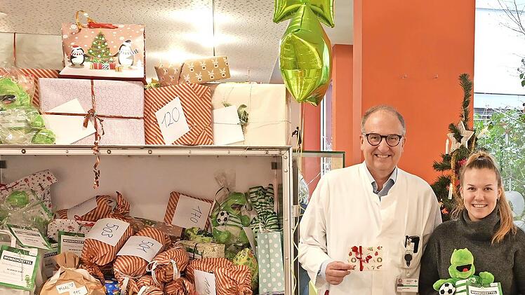 Wenn die &bdquo;Kleebl&auml;tter&ldquo; bescheren, darf einer nicht fehlen: Pl&uuml;sch-Maskottchen &bdquo;Eddy&ldquo;. Antonia Karl, Mitarbeiterin im Bereich Nachhaltigkeit der SpVgg Greuther F&uuml;rth, &uuml;bergab die 100 P&auml;ckchen an Joachim W&ouml;lfle, Direktor der Kinder- und Jugendklinik...