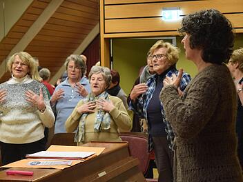 Bevor die Proben fürs Adventskonzert zum 70-jährigen Bestehen starten können, wärmen sich die Mitglieder mit Chorleiterin Carolin Heckel auf. Foto: Daniela Pondelicek
