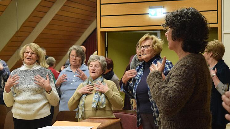 Bevor die Proben fürs Adventskonzert zum 70-jährigen Bestehen starten können, wärmen sich die Mitglieder mit Chorleiterin Carolin Heckel auf. Foto: Daniela Pondelicek