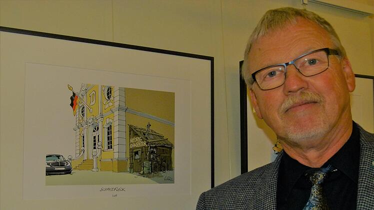 Manfred Böhm, Leiter der Betriebsseelsorge, vor seiner Lieblingskarikatur von Luff zum Thema Niedriglohn.