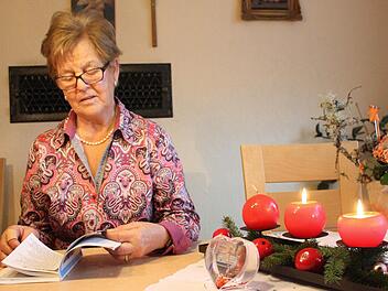 Luise Mahlmeister blättert in einem Liederbuch. Damals wie heute wird Heilig Abend gesungen.  Foto: Robert Huger