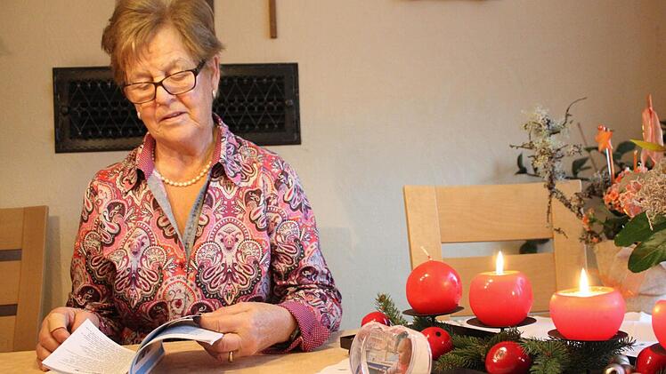 Luise Mahlmeister blättert in einem Liederbuch. Damals wie heute wird Heilig Abend gesungen.  Foto: Robert Huger