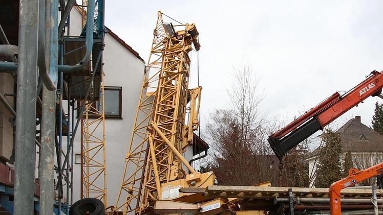 Ein umgestürzter Kran liegt auf dem Giebel eines Hauses in Forchheim. Der Kran verursacht einen Schaden von rund 100.000 Euro. Foto: Josef Hofbauer