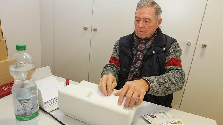 Bernhard Schotte schlitzt die Kinderbriefe mit der Maschine auf.