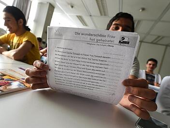 Minderj&auml;hrige Fl&uuml;chtlinge im Deutsch-Kurs, einer zeigt das Lehrmaterial. Foto: Felix K&auml;stle/dpa