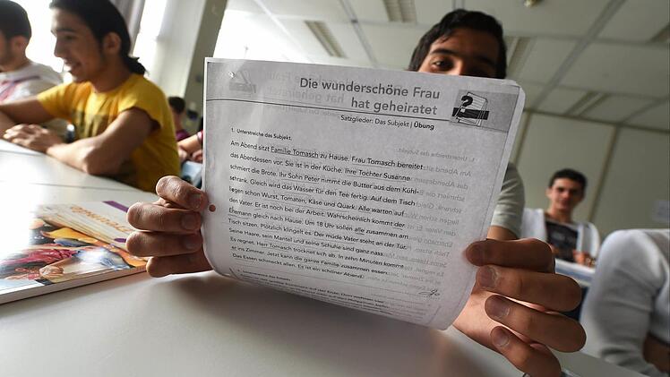 Minderj&auml;hrige Fl&uuml;chtlinge im Deutsch-Kurs, einer zeigt das Lehrmaterial. Foto: Felix K&auml;stle/dpa