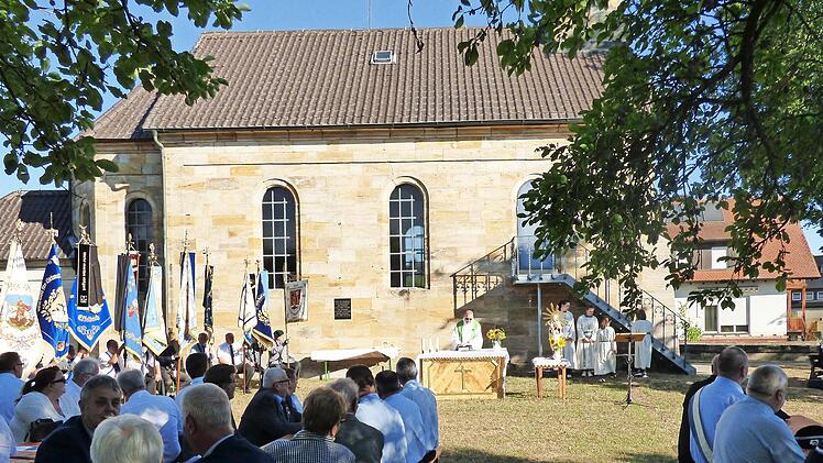 Pfarrer Michael Gehret spricht vor der Marienkapelle zu den Versammelten.