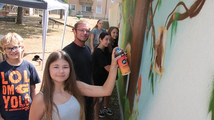Die elfjährige Johanna (ganz vorne) ist eine von neun Jugendlichen, die im Rahmen des Ferienprogramms mit Sprühdosen eine Wand des Spielplatzes in der Tilsiter Straße gestaltet haben. Angeleitet haben die Aktion der Meininger Künstler Thorsten Grü...
