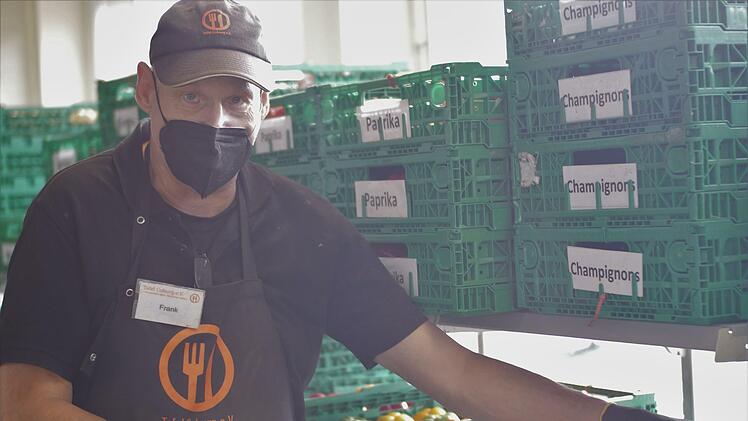 Frank schleppt für die Damen Obst- und Gemüsekisten.