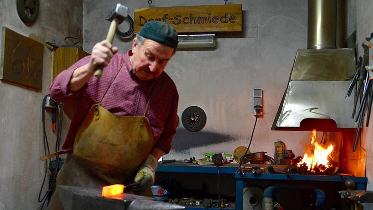 Winfried Geis an seinem Amboss. Hier bearbeitet er einen Metallklotz, aus dem ein Damastmesser entstehen soll. Foto: Kathrin Kupka-Hahn